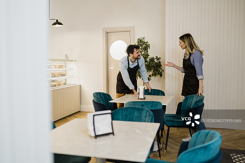 服务人员调整椅子并准备吧台图片素材