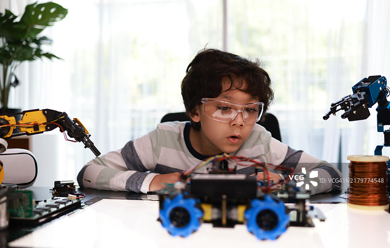 专注组装编程机器人汽车的小学生图片素材