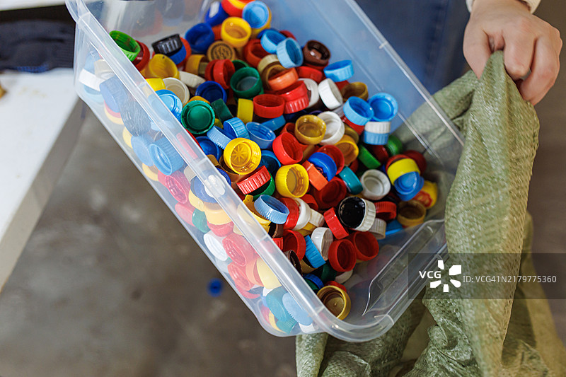 五颜六色的塑料瓶盖在容器中被分类以便回收图片素材