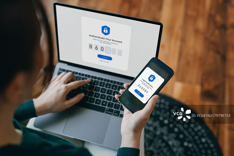 年轻亚裔女子使用双重验证登录笔记本电脑的肩上视角图片素材