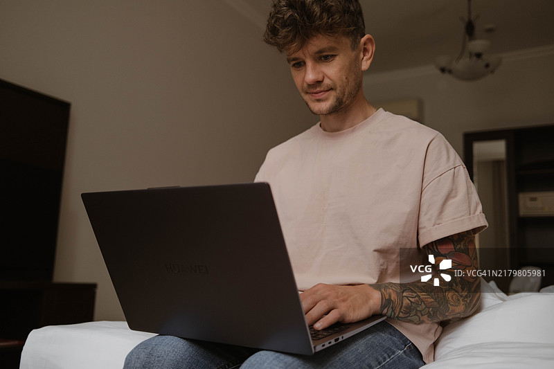 在酒店用笔记本电脑工作的男人图片素材
