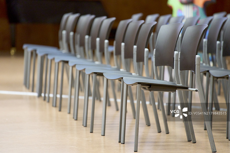 礼堂里一排排空的金属椅子的侧视图图片素材
