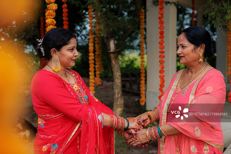 两位美丽的印度女性身着传统服饰，化着妆，正在享受节日庆祝活动。图片素材