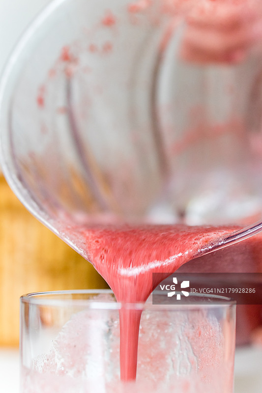 玻璃杯中供应的甜菜蓝莓冰沙图片素材