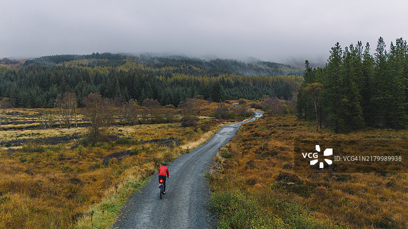 苏格兰斯凯岛砂石路上骑行者的无人机航拍图片素材