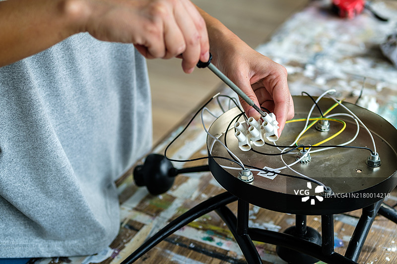 女人双手正在处理灯具安装的电线图片素材