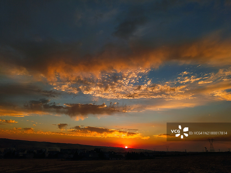 日落时分，天空映衬下的田野美景图片素材