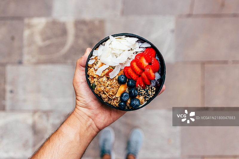 手持含新鲜水果和浆果的阿萨伊果碗，个人视角图片素材