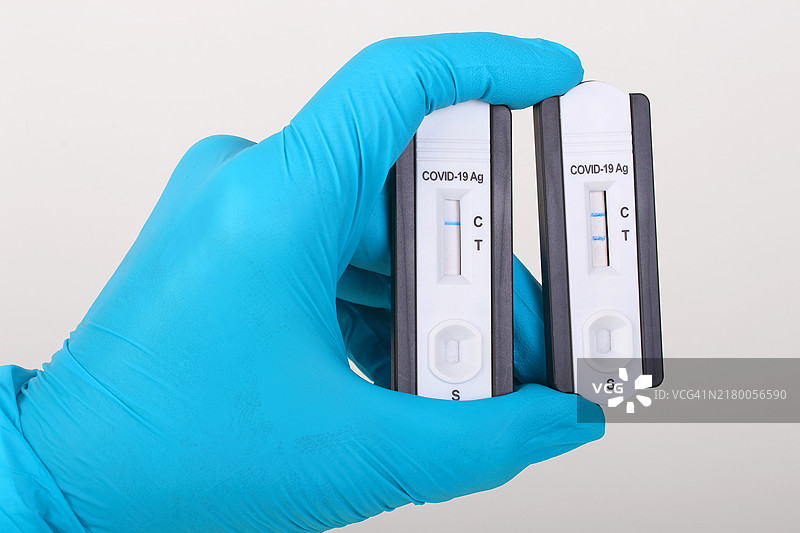 手持新冠病毒PCR快速检测阳性和阴性结果图片素材