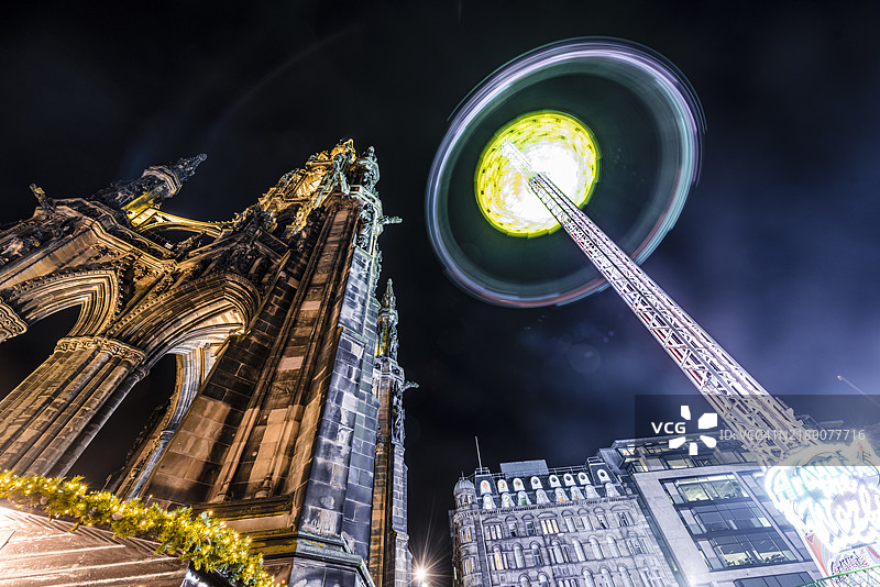 爱丁堡圣诞市场旋转木马和夜间司各特纪念碑，苏格兰爱丁堡，英国图片素材