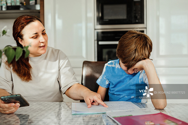 可爱的男孩在家和妈妈一起做作业图片素材