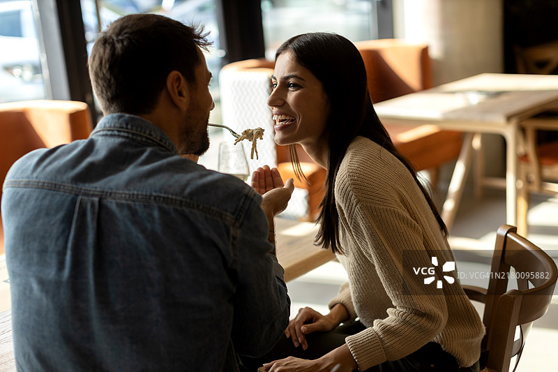 在餐厅里享用意大利面的恩爱情侣图片素材