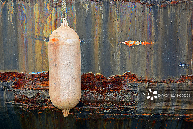 德国生锈船壁前的粉色挡泥板图片素材