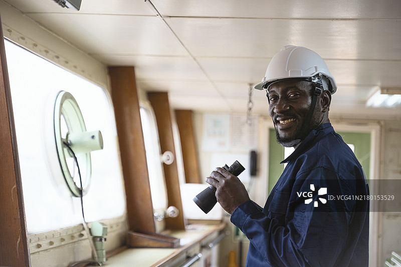 在集装箱货船的桥梁或控制区域工作的团队肖像，适用于商业物流进出口运输或货运。图片素材