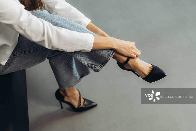年轻女人系黑色细高跟鞋鞋带。图片素材