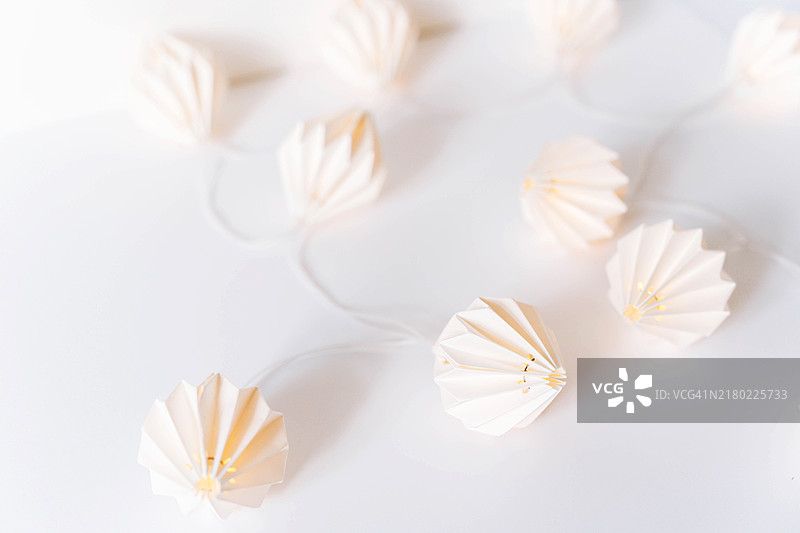 白色桌子背景上的圣诞节折纸灯笼花环图片素材