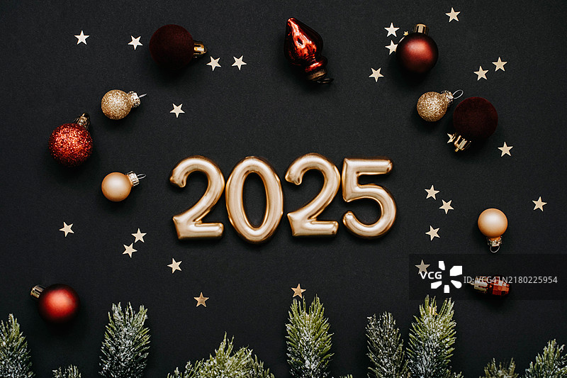 金色2025数字的庆祝平铺设计，周围环绕着金色星星彩带和节日装饰图片素材