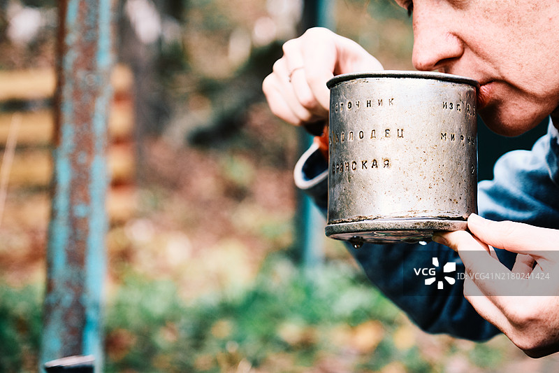女游客在圣泉边用勺子喝水图片素材