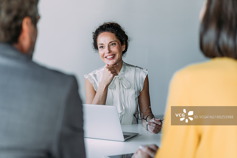 一群商务人士在办公室交谈。图片素材