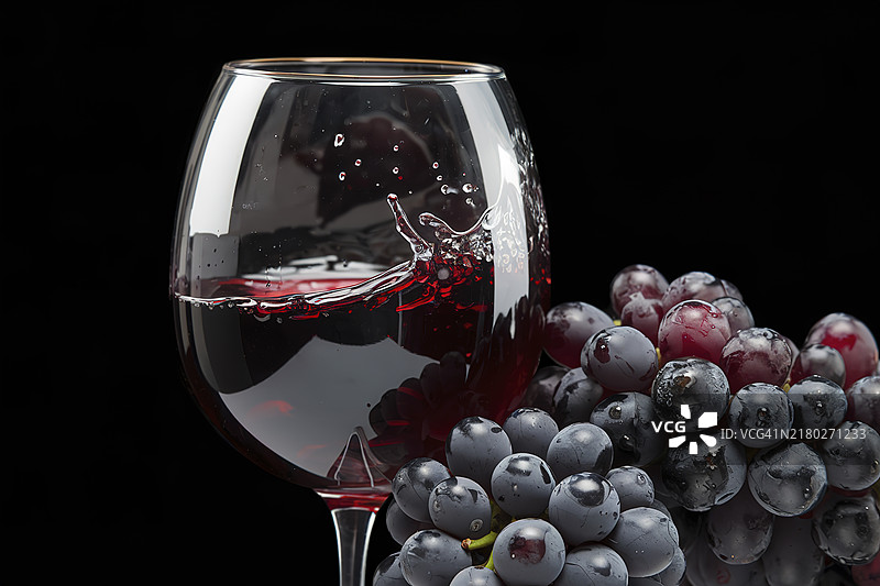 一杯装满红酒的玻璃杯，旁边放着一串深紫色的葡萄，呈现出电影般的画面。图片素材