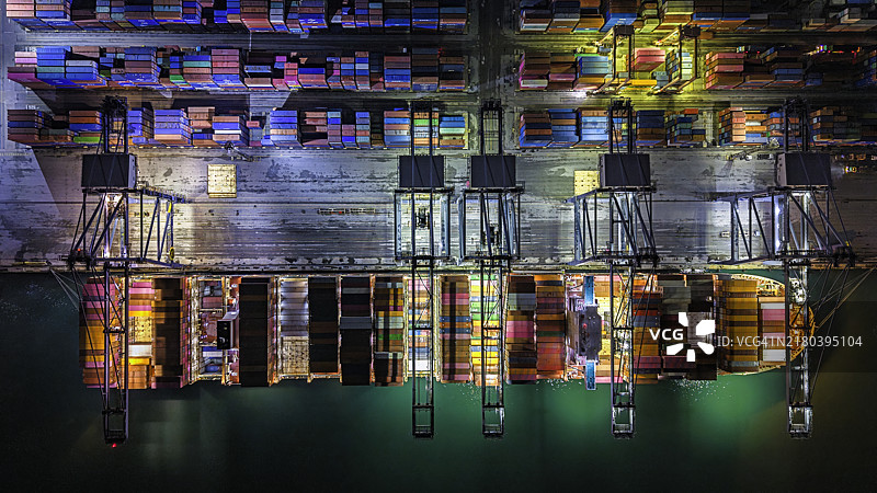 夜间起重机装载集装箱的航拍视角。图片素材