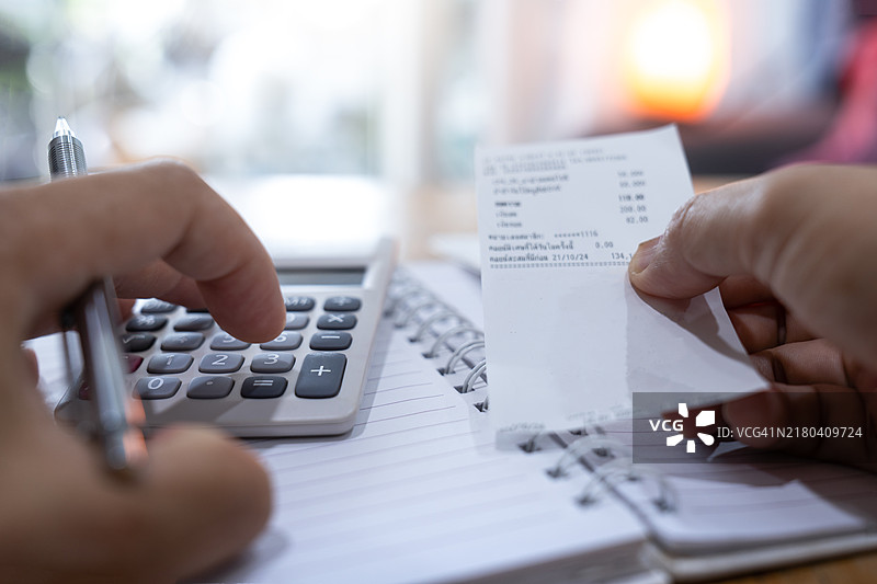 女人使用计算器和笔记本电脑计算每月预算、家庭支出、抵押贷款、租金和在线支付账单图片素材