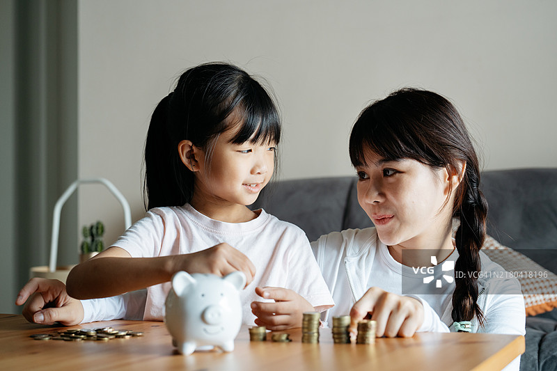 年轻的亚洲女孩学习如何存钱图片素材