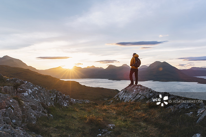 徒步旅行者在日出时俯瞰苏格兰高地托里登湖的背影图片素材