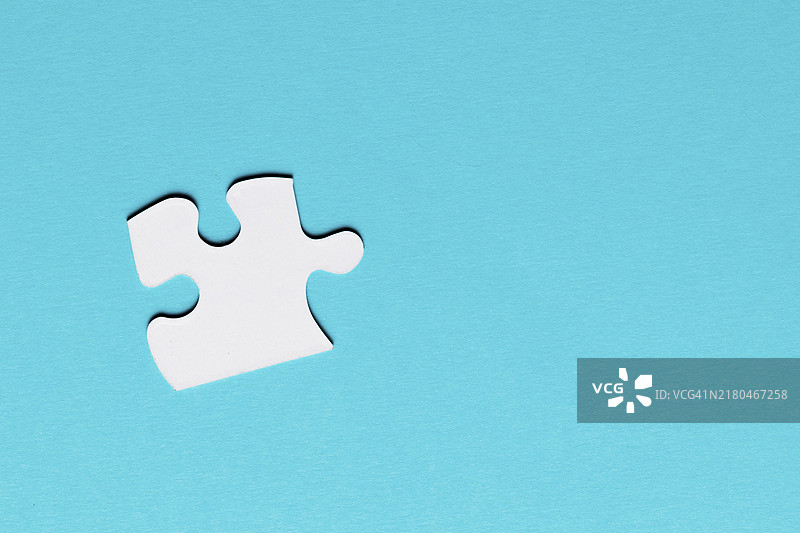 蓝色背景上的白色单块拼图图片素材