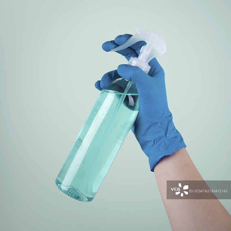 戴着外科手套的手使用消毒剂图片素材
