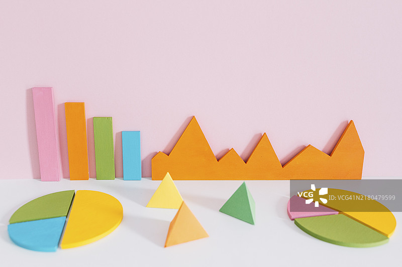 粉色背景下具有金字塔形状的不同彩色图表图片素材