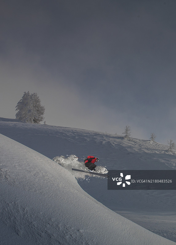 滑雪者在雪坡上跳跃图片素材