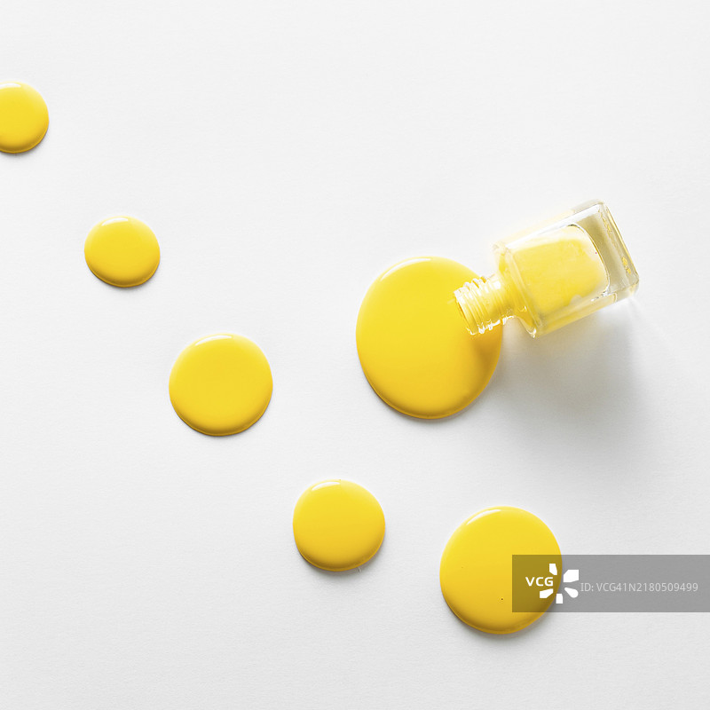 俯视：黄色指甲油，白色背景图片素材