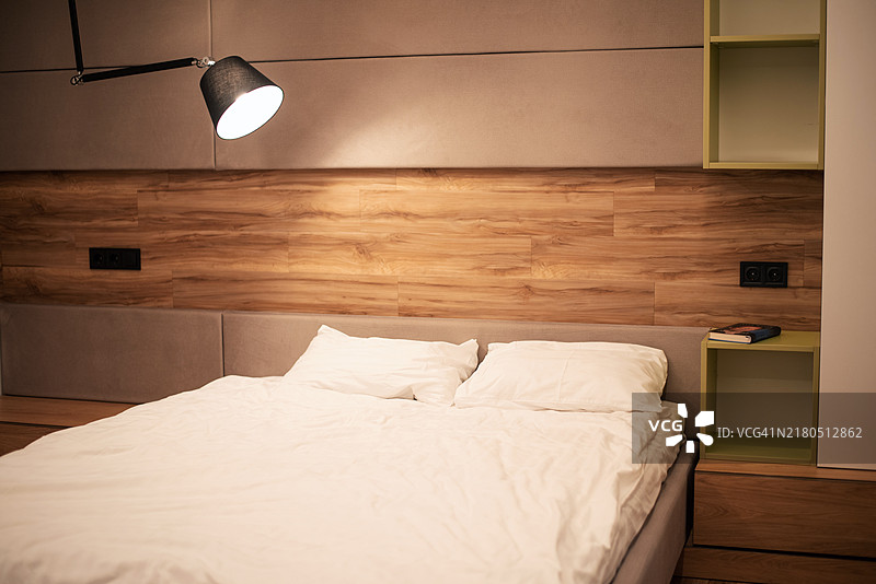 带有床头灯的床。夜晚的室内。床上的关系。性亲密个人生活。图片素材