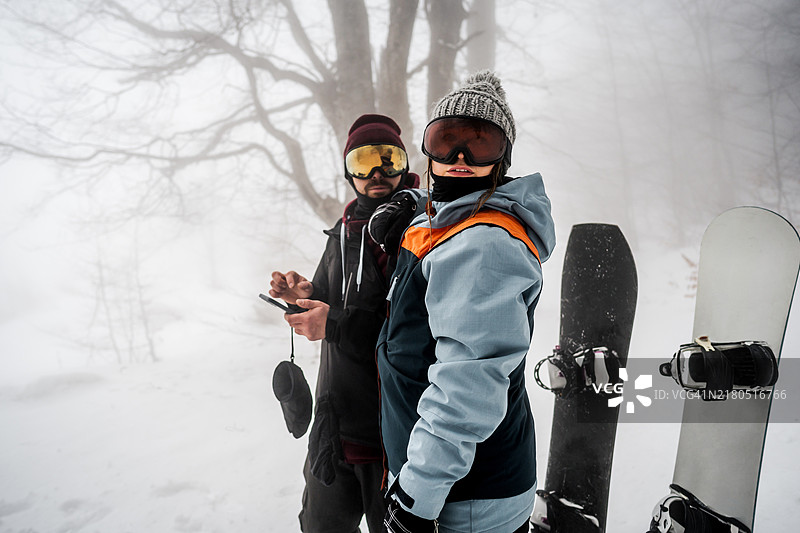 在雪山上使用手机的滑雪者图片素材