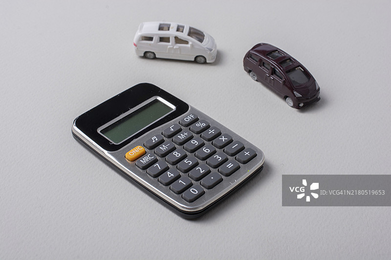 白色背景上计算器旁的小汽车图片素材