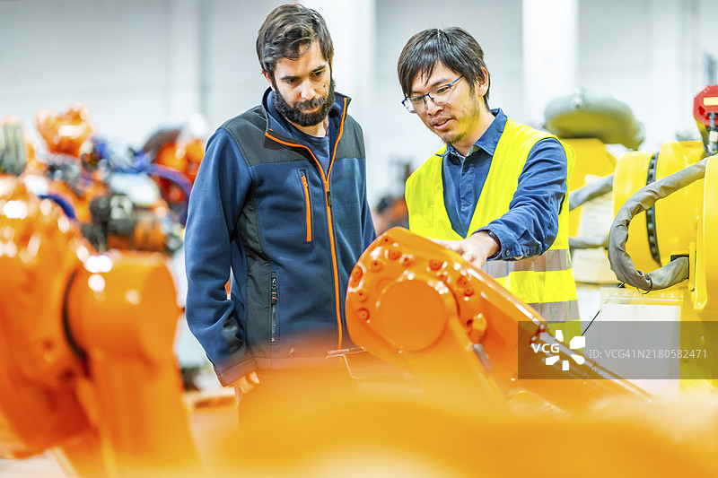 国际工程师团队控制机器人生产线图片素材