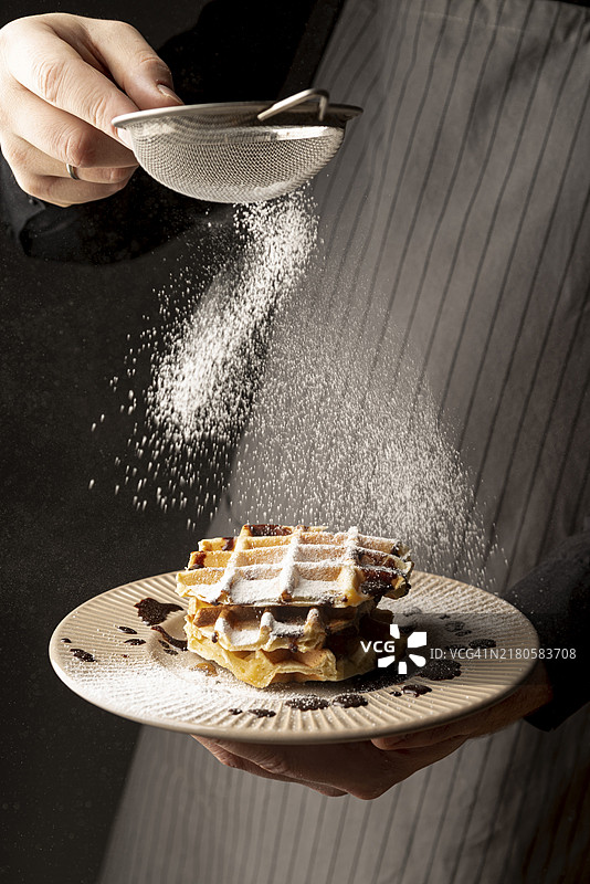 给华夫饼撒糖粉的男人正面图图片素材