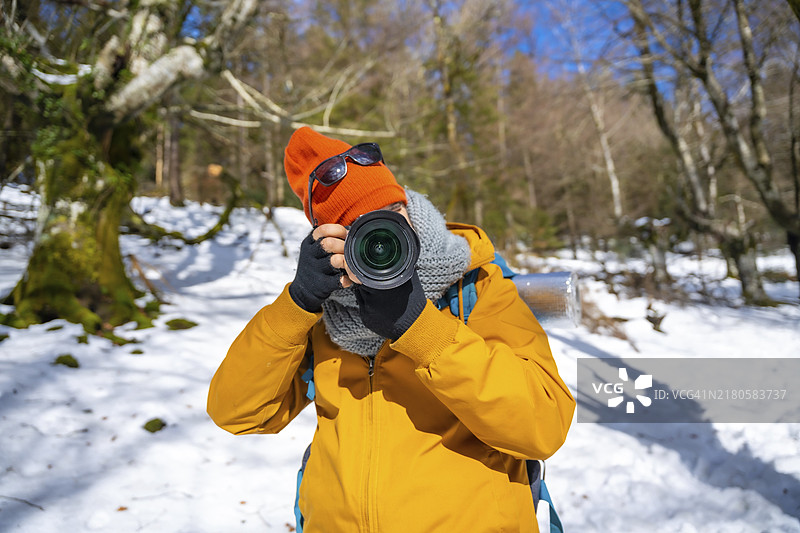 摄影师在雪山中徒步旅行拍摄冬季照片的肖像图片素材