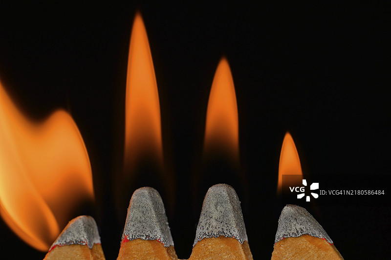 火柴头上的四簇火焰，黑色背景的摄影棚照片图片素材