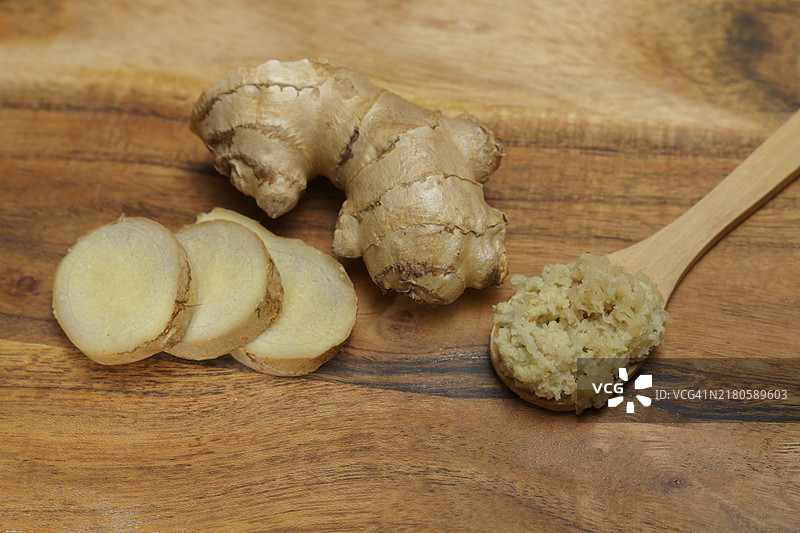 木勺中的姜粉和新鲜的姜根切片图片素材