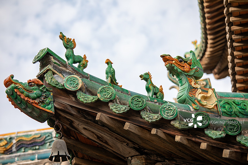 古老的飞檐结构，配有琉璃屋顶兽、瓦片和木制斗拱框架。图片素材