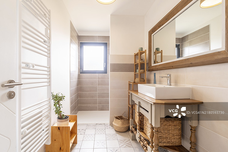 家庭浴室：明亮的新浴室内部，配有瓷砖玻璃淋浴、梳妆台和白色与稻草混合的内饰图片素材