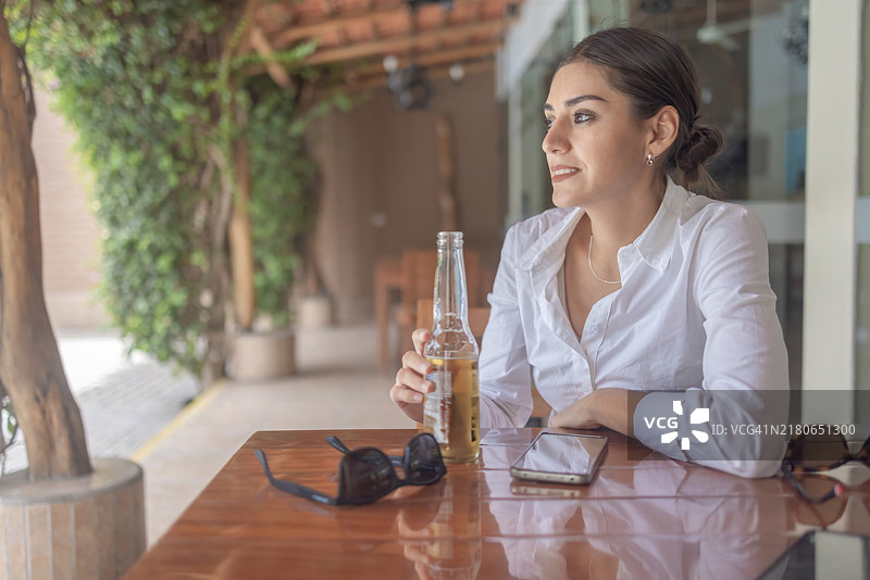 在露台上享受啤酒的女人图片素材