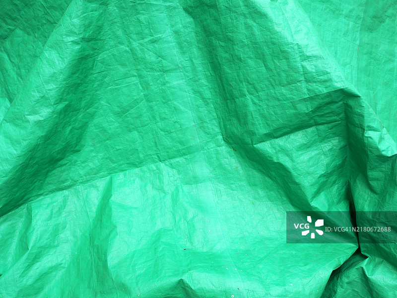 在法国巴黎的一块绿色皱纹塑料布。粗糙的纹理。自然光和色彩。图片素材
