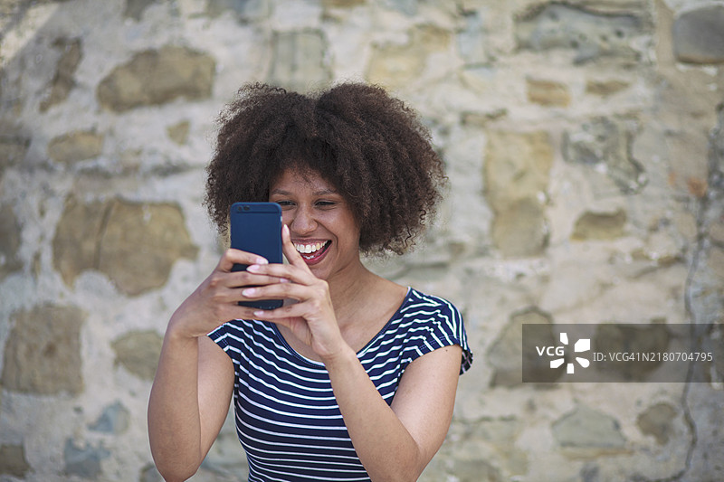 非裔美国妇女用智能手机拍照图片素材