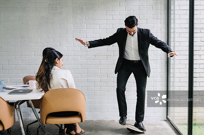 印度亚洲商人在办公室开会时进行平衡练习。图片素材