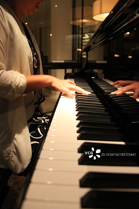 女性手在弹钢琴。图片素材