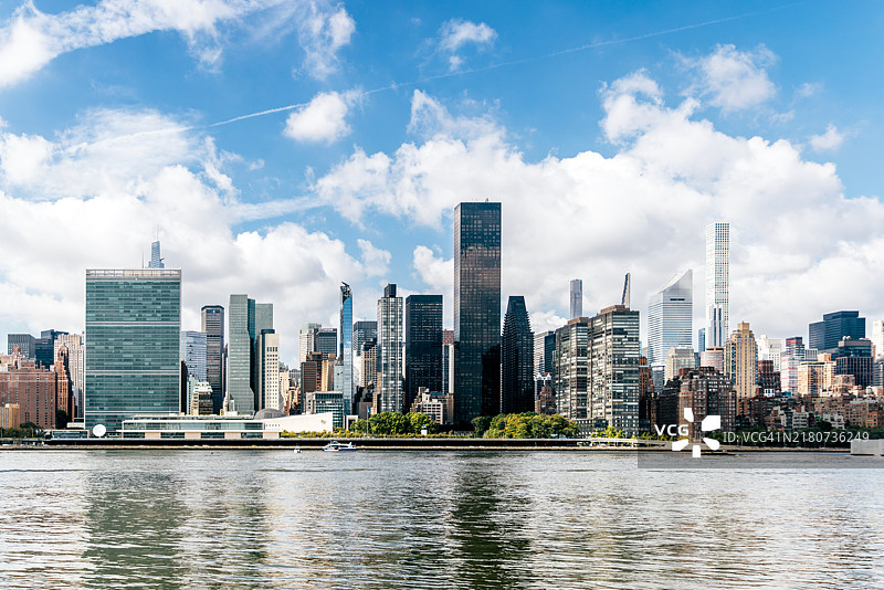 晴朗多云天气下，美国纽约曼哈顿中城和东河的摩天大楼图片素材