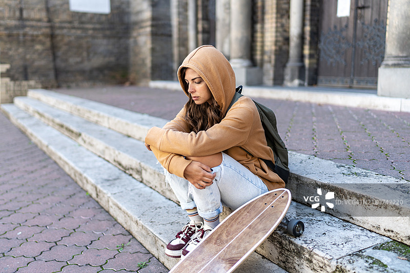 沮丧的年轻女子坐在户外图片素材